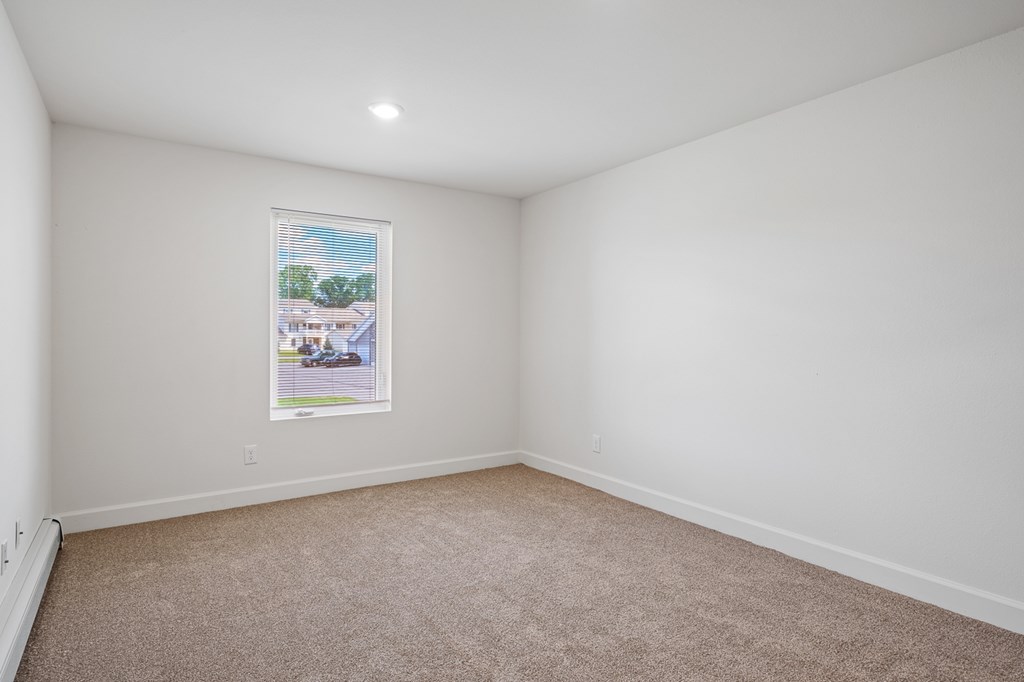 A white wall with a framed picture of a house on it.