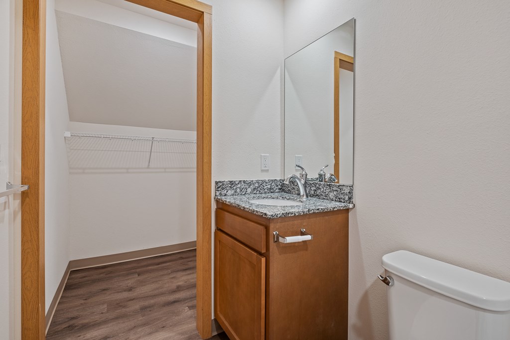 A small bathroom with a sink, mirror, and bathtub.