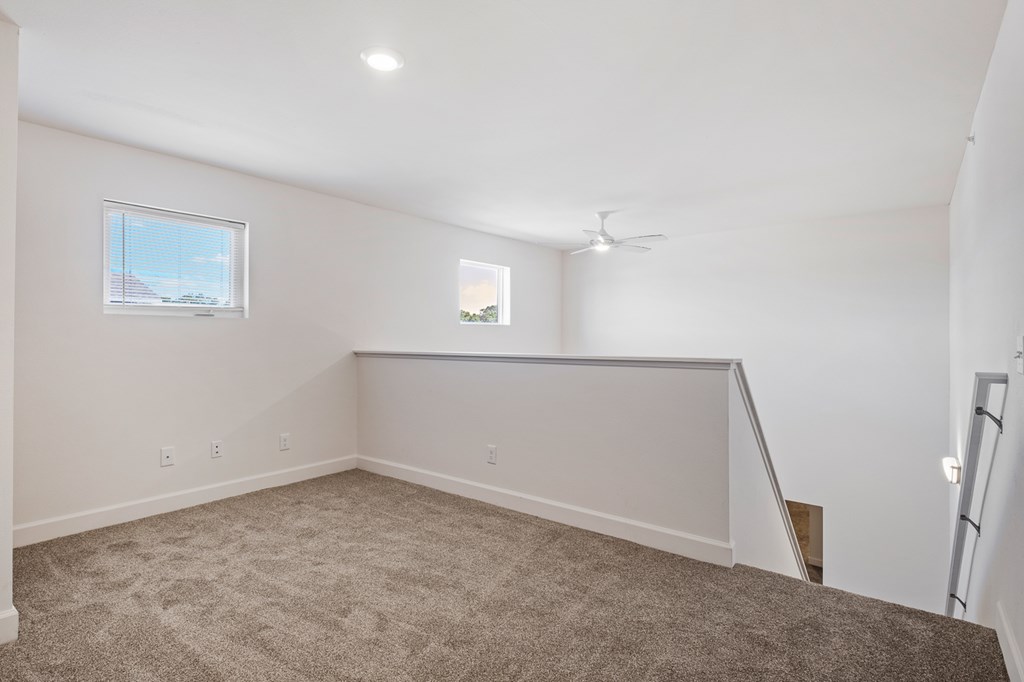 A room with a carpeted floor and a window.