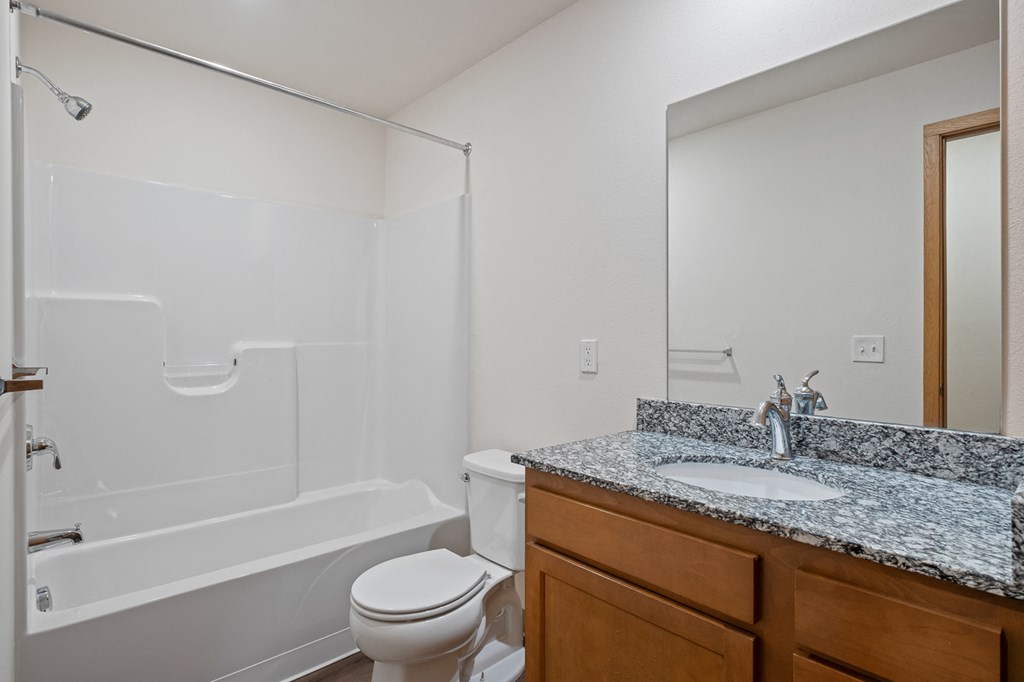 A white bathroom with a toilet, sink, and bathtub.