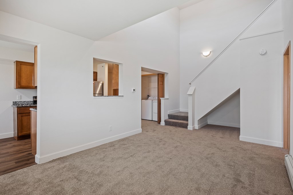 A spacious living room with a staircase leading to the upper floor.