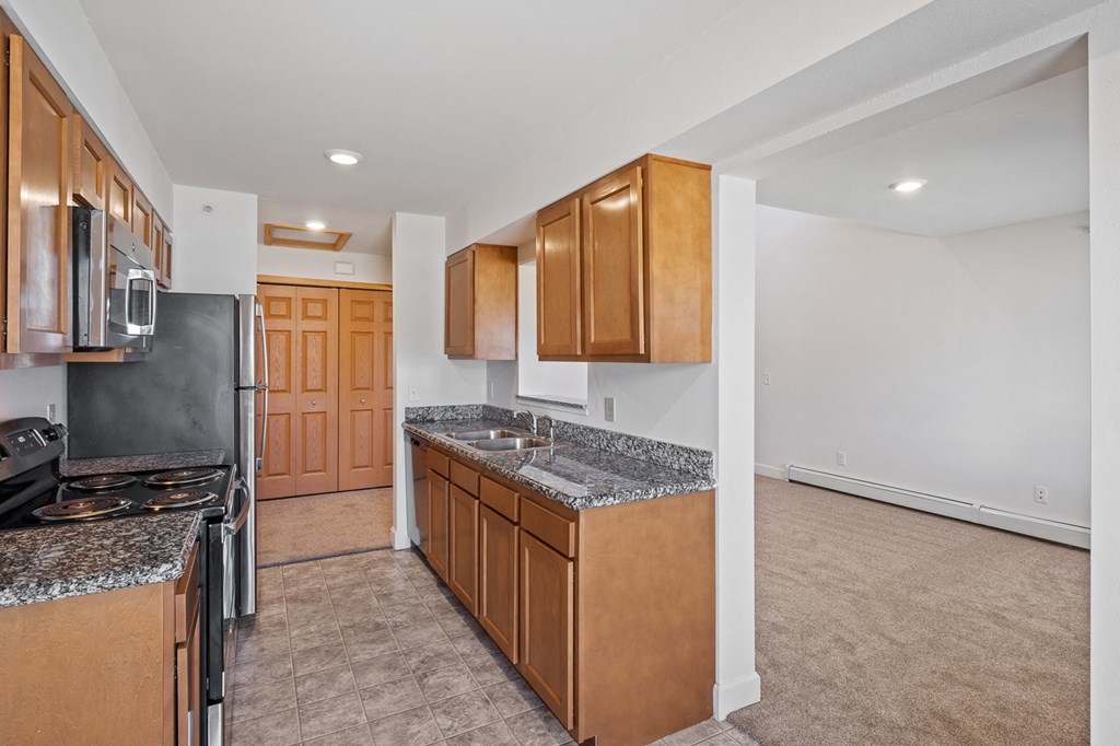 A kitchen with wooden cabinets and a granite countertop.