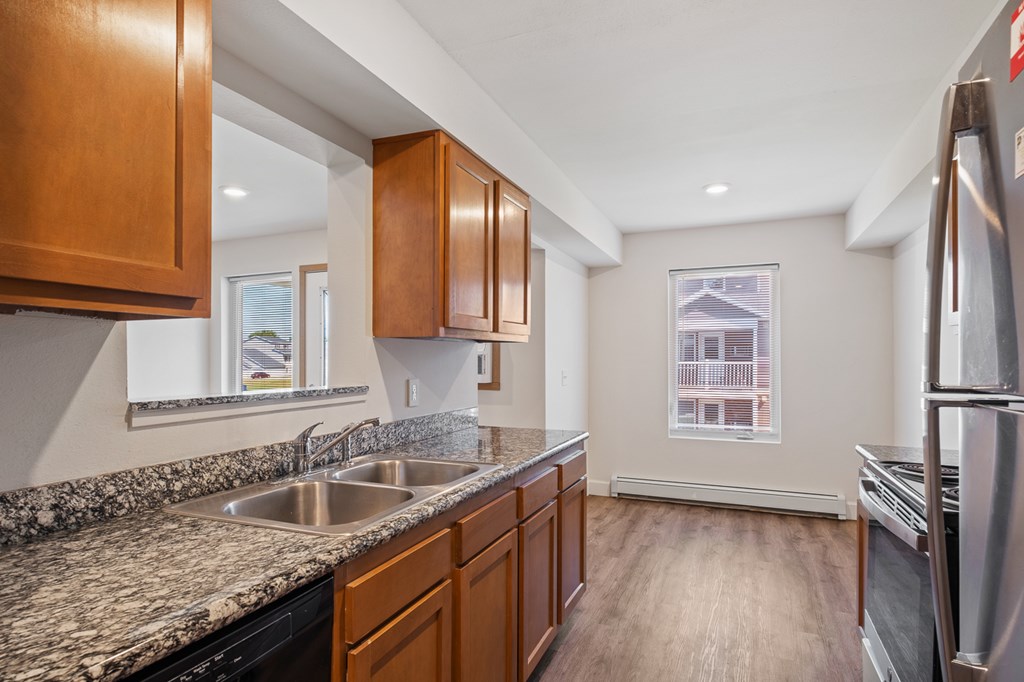 A kitchen with wooden cabinets and a granite countertop.