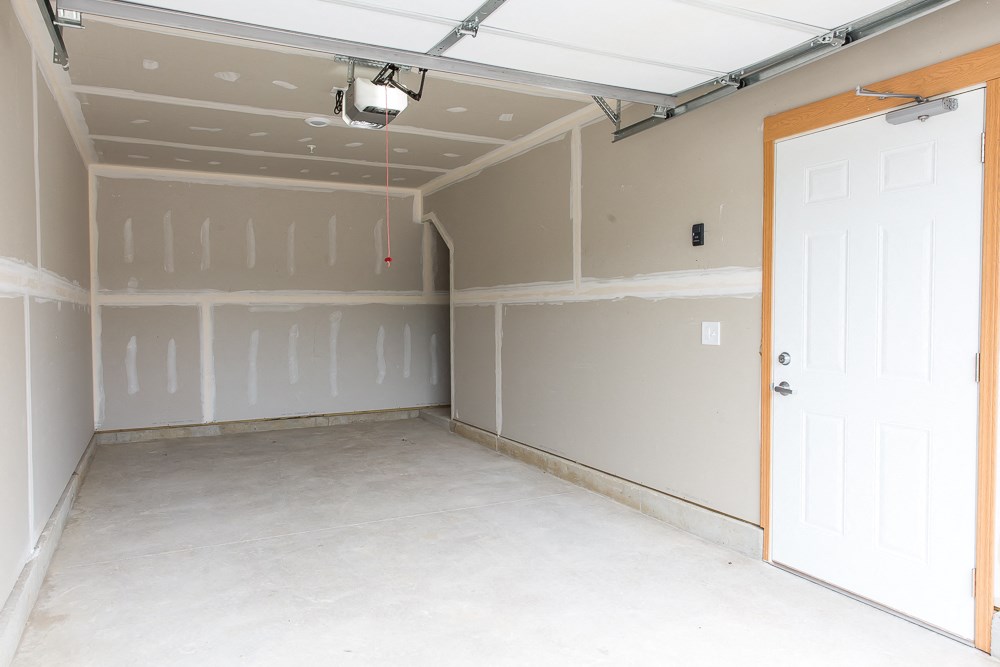 an empty garage with white walls and a white door