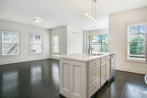 an empty kitchen and living room with a sink and window