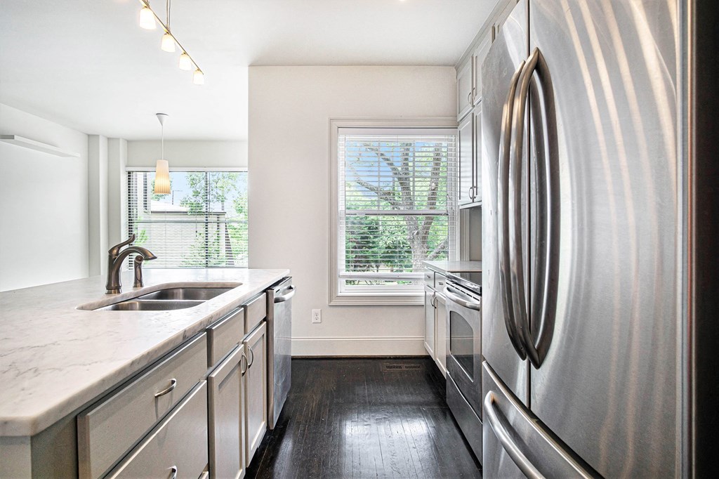 a kitchen with stainless steel appliances and white counter tops