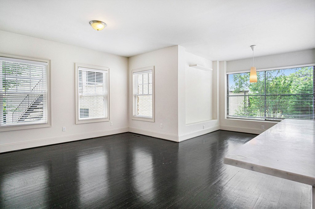 an empty living room with a large window and a table