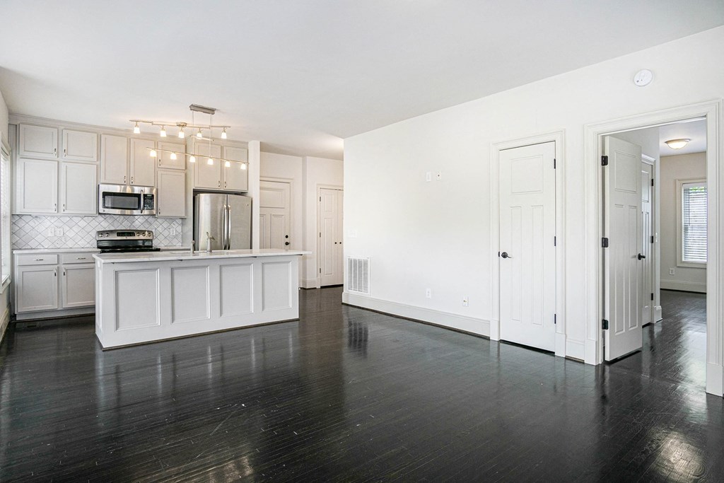 an empty kitchen with white cabinets and a counter top