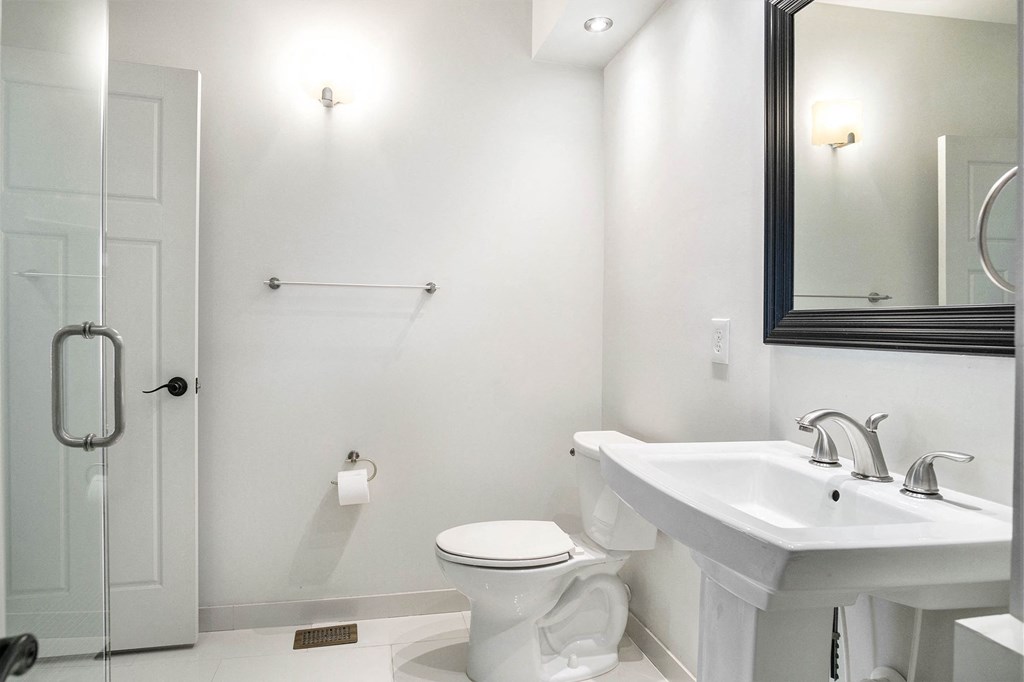 a bathroom with a sink toilet and a mirror