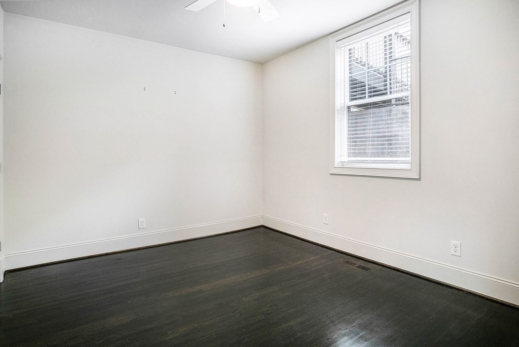 an empty room with white walls and a window