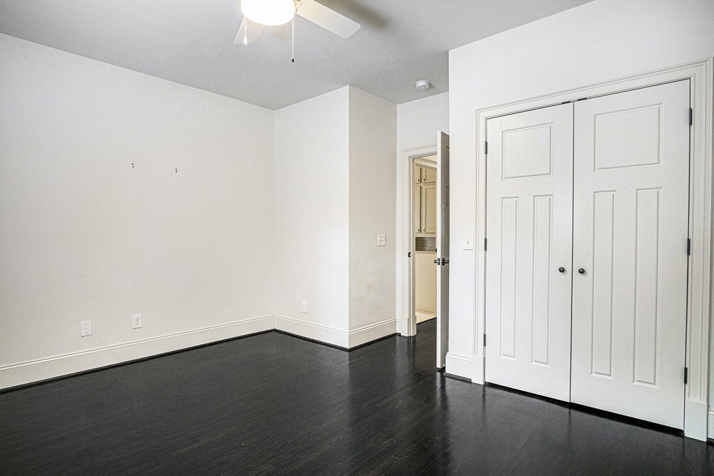 an empty living room with white walls and a ceiling fan