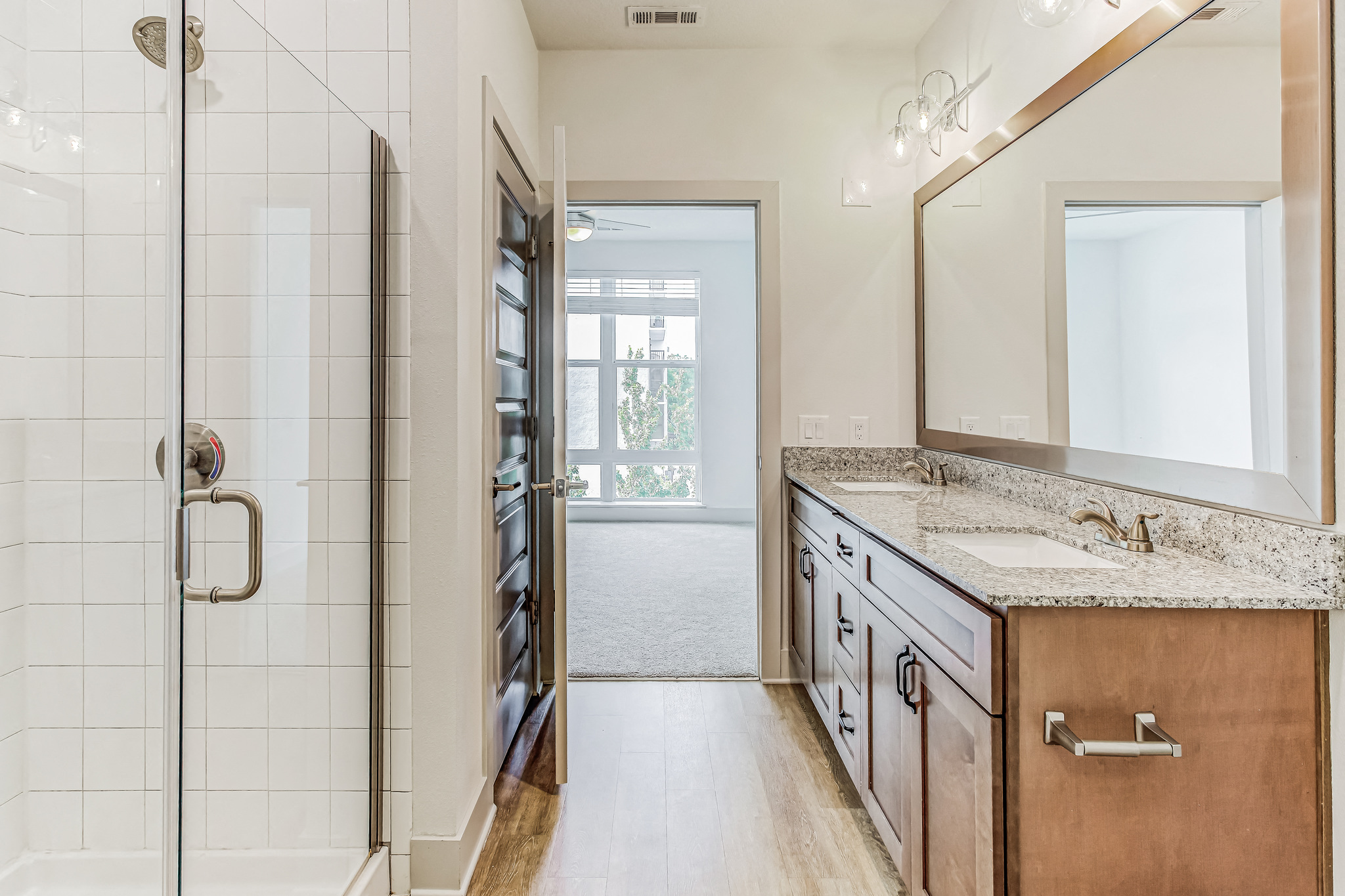 a bathroom with a shower and a sink and a mirror