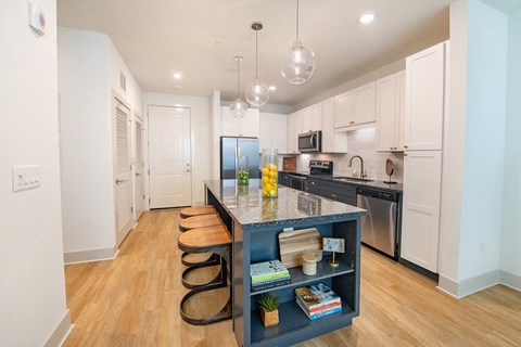 a kitchen with a large island with stools