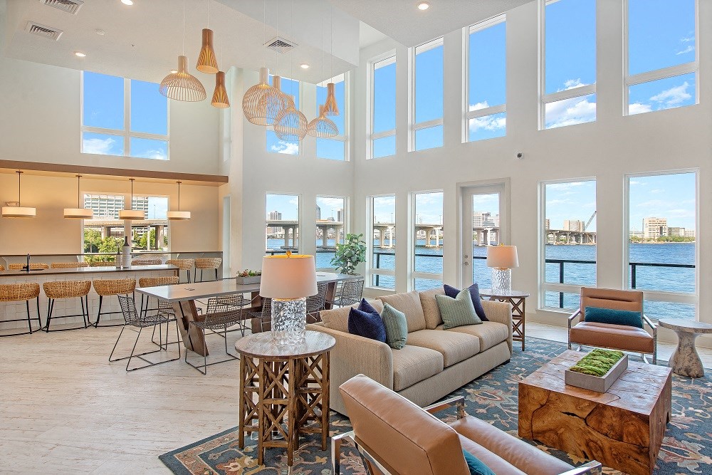 a living room with high ceilings and a view of the water