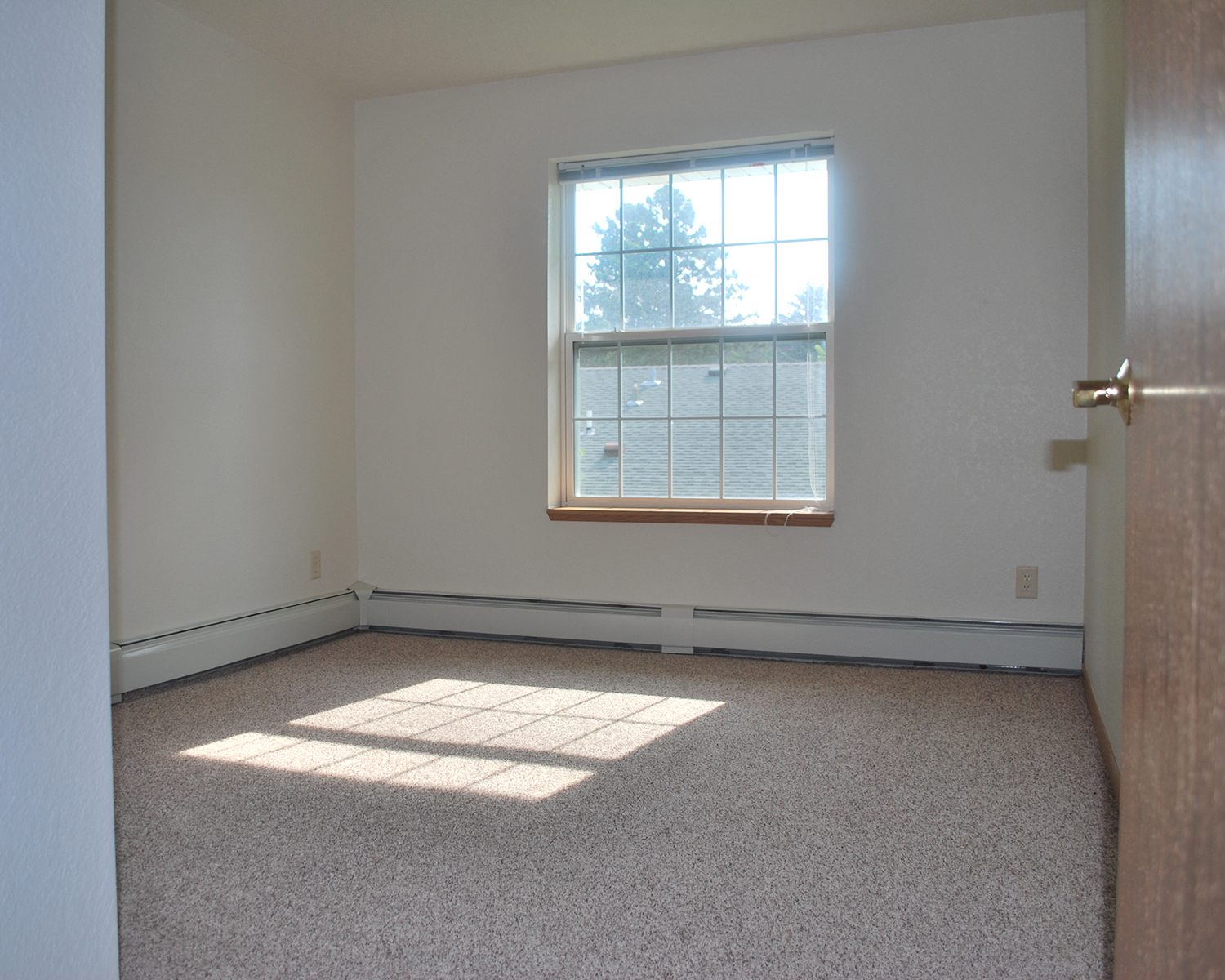 an empty room with a window and a door