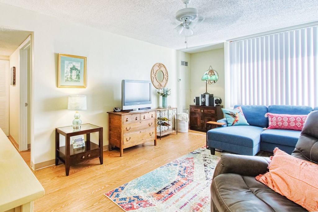 spacious living room with large window, wood-style flooring, and ceiling fan