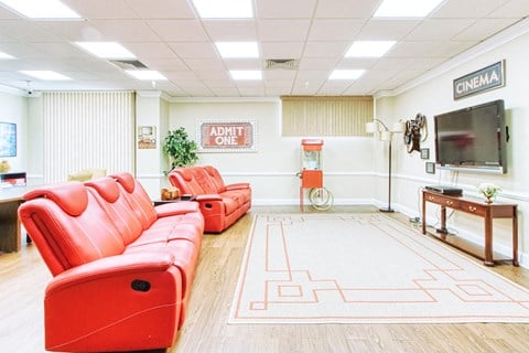 a living room with red chairs and a tv