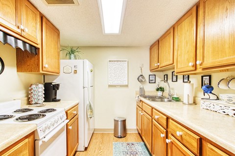a kitchen with wooden cabinets and a white stove and refrigerator