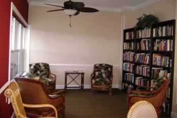 library with shelves full or books, seating, and ceiling fan