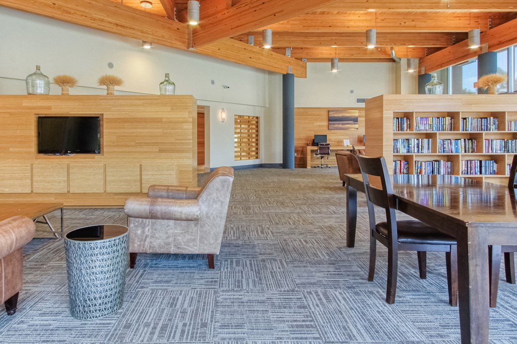 large lobby with tables, chairs, and shelves full of books