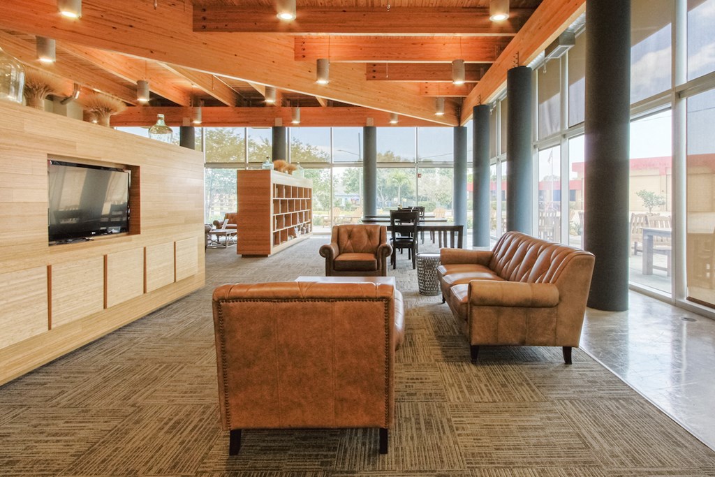 large sitting area with TVs beside floor to ceiling windows