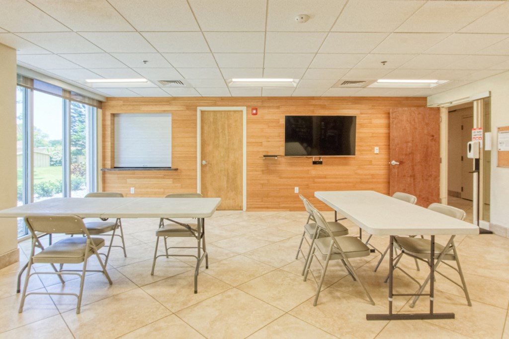Community1 community room with tables and TV