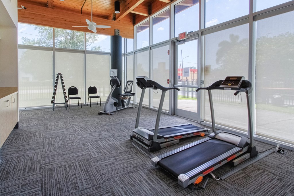 fitness center with cardio equipment and free weights 