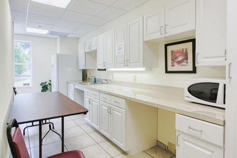 a kitchen with white cabinets and a table