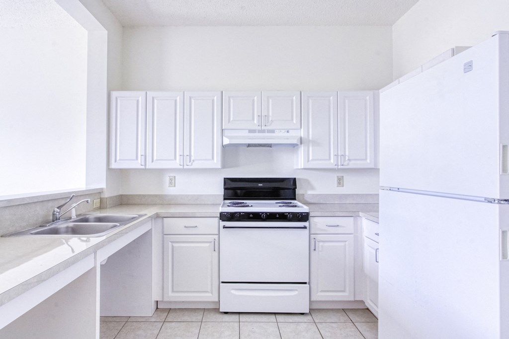neat kitchen with efficient white appliances and white cabinetry