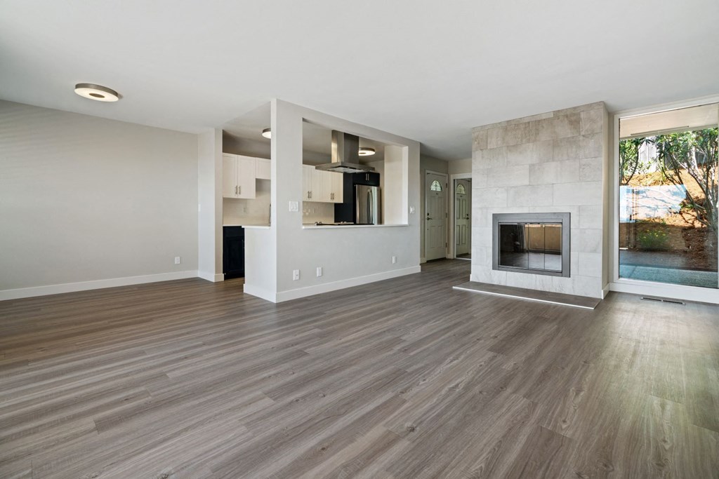 a living room with a fireplace and a kitchen