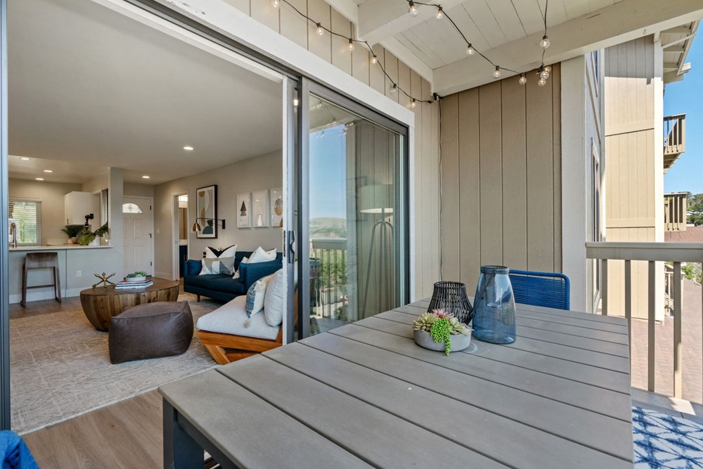 a living room with a wooden table and sliding glass doors