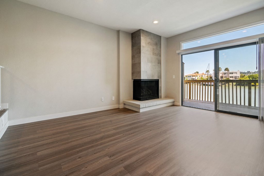 an empty living room with a fireplace and a balcony