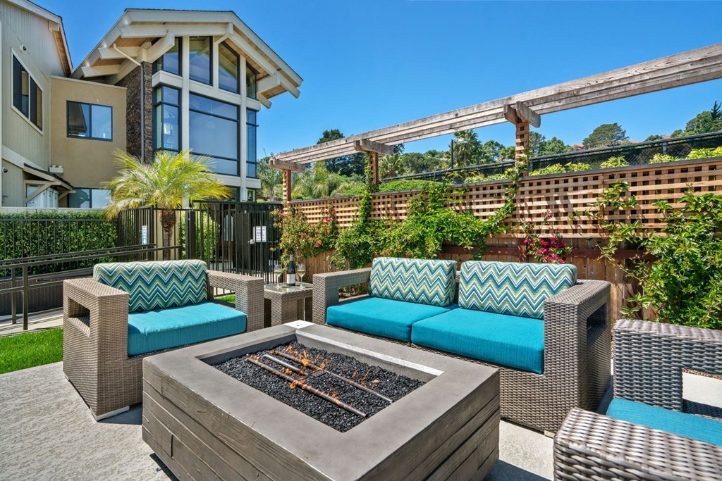 a patio with chairs and a fire pit