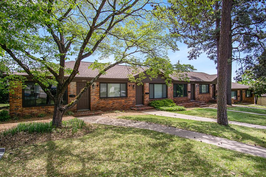 the front of a brick house with trees
