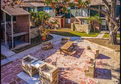 a backyard with a picnic table and chairs in a courtyard
