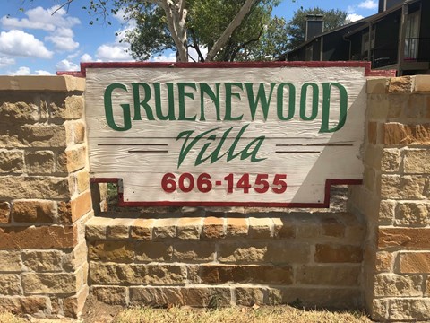 a sign in front of a brick wall