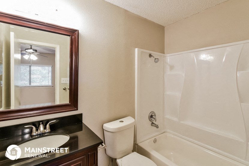 a bathroom with a shower sink and toilet and a mirror