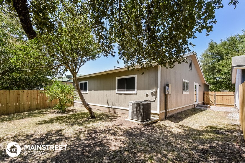 a backyard with a house and a tree