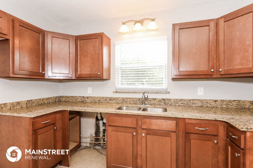 a kitchen with wooden cabinets and granite counter tops and a sink