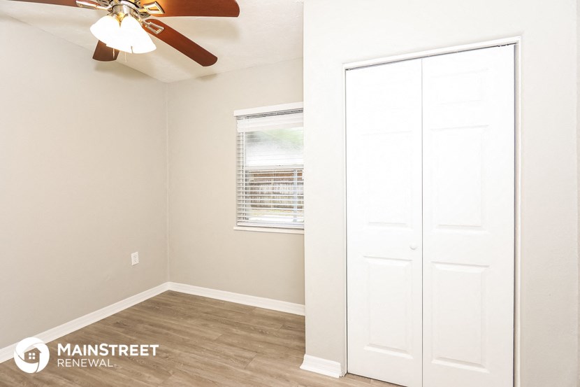 a bedroom with a closet and a ceiling fan