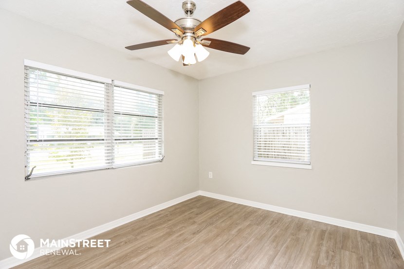 a living room with a ceiling fan and a window