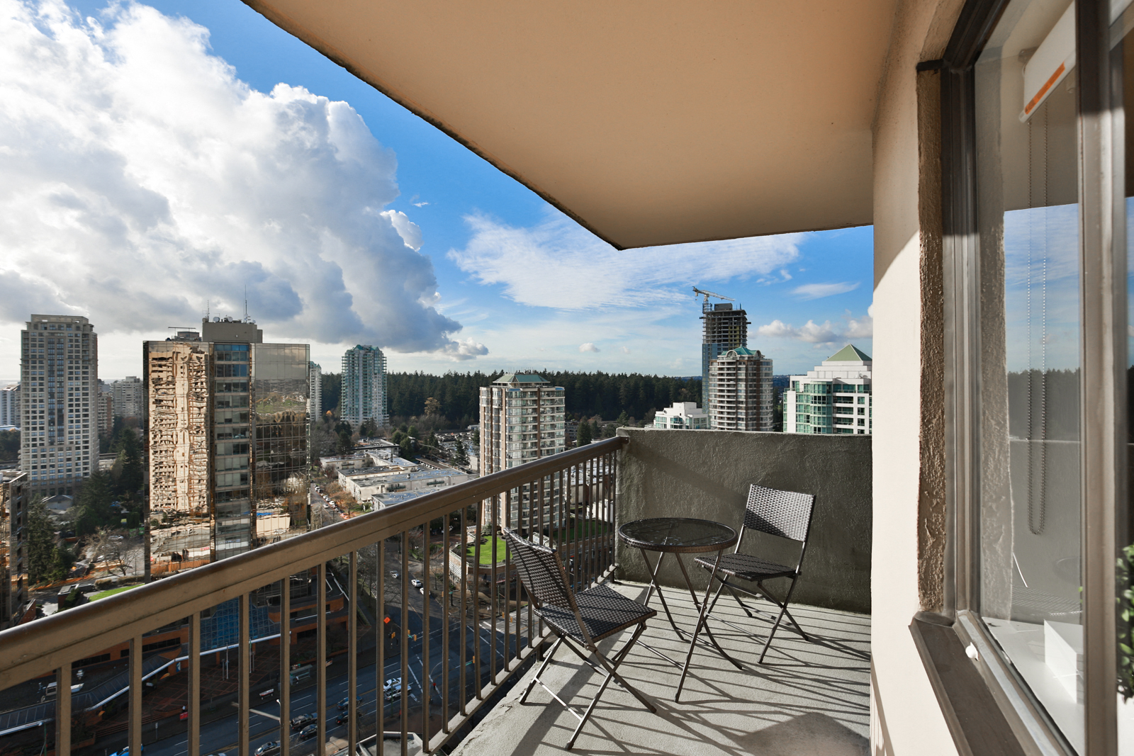 a balcony with a view of the city and a table and chairs