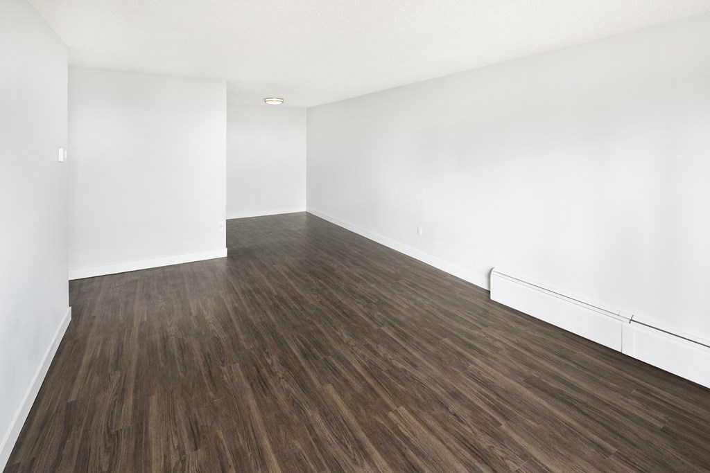 an empty room with wood floors and white walls