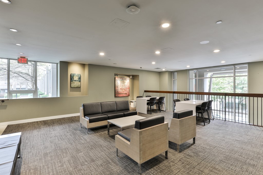 a lounge area with couches and chairs and a table with chairs