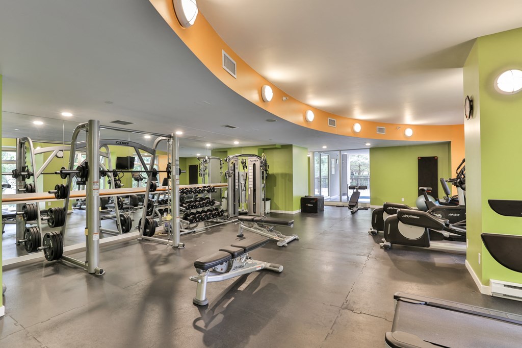 a gym with weights and other exercise equipment in a building with green walls