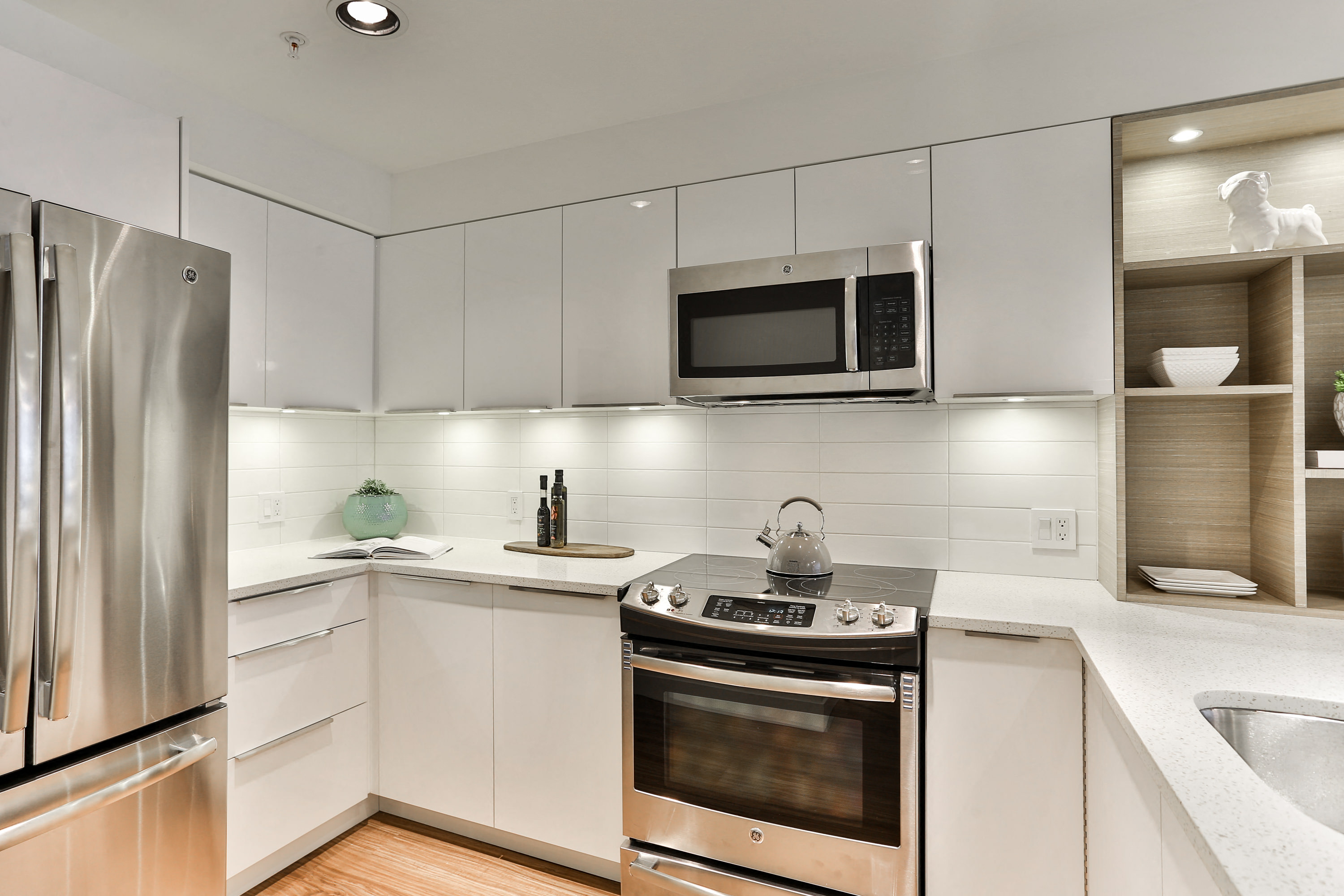 a modern kitchen with stainless steel appliances and white cabinets
