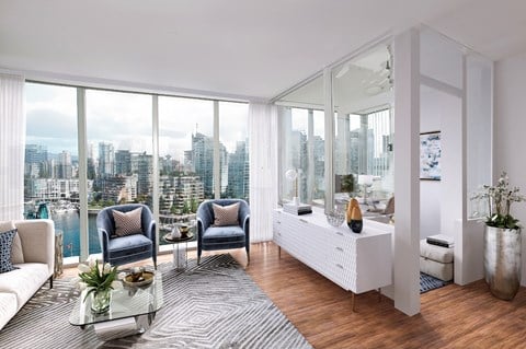 an open living room with a view of the city and a rug and a table