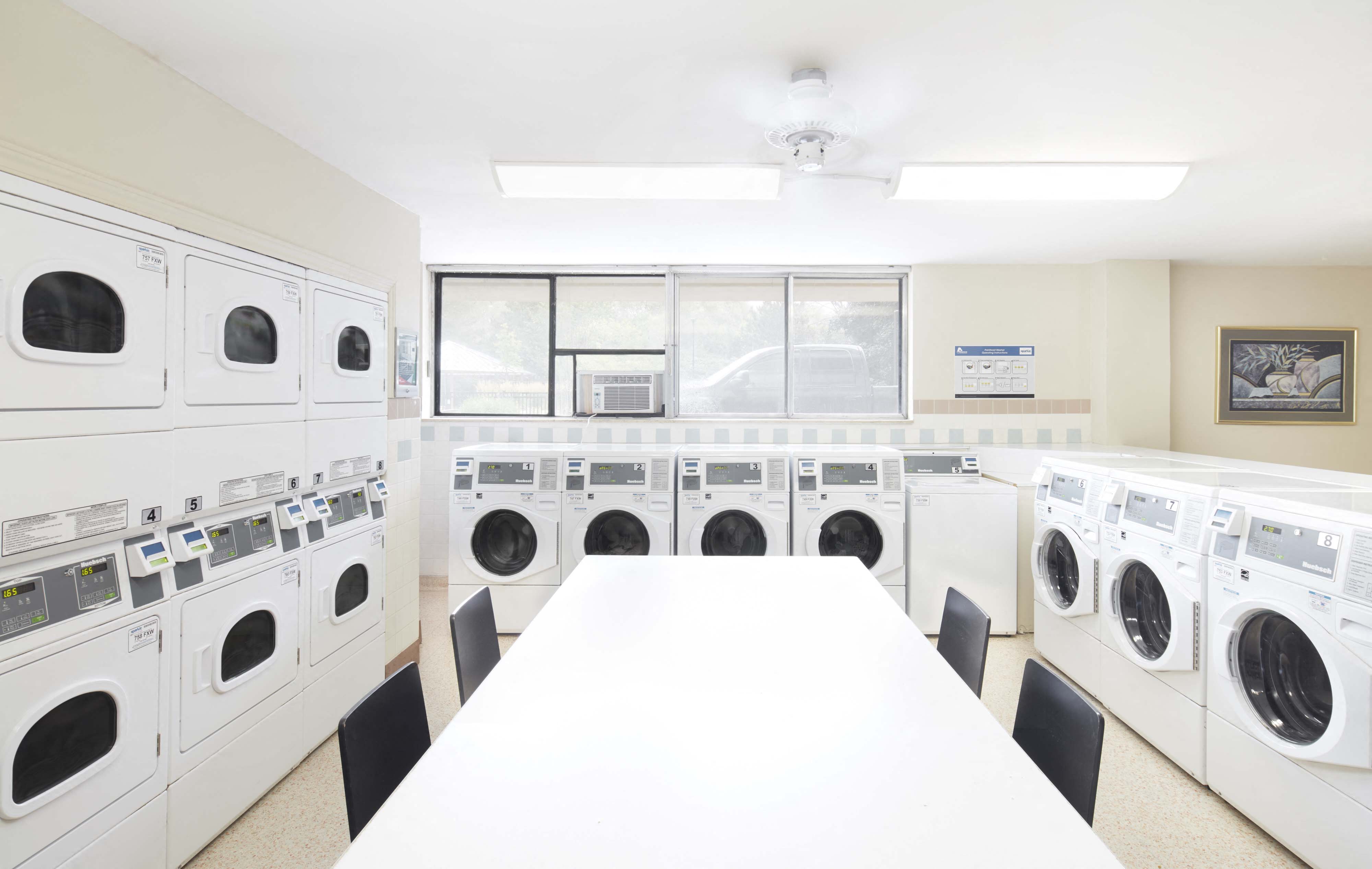 a washer and dryer room with a table and washing machines