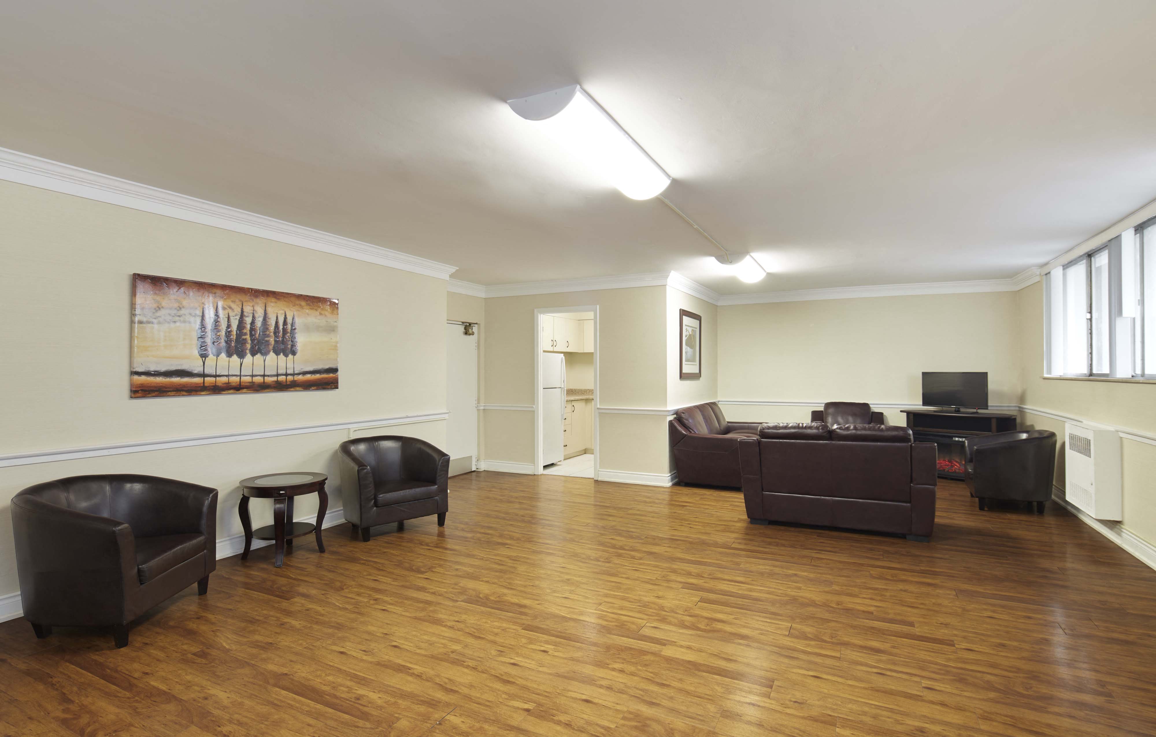 a living room with leather furniture and a hard wood floor