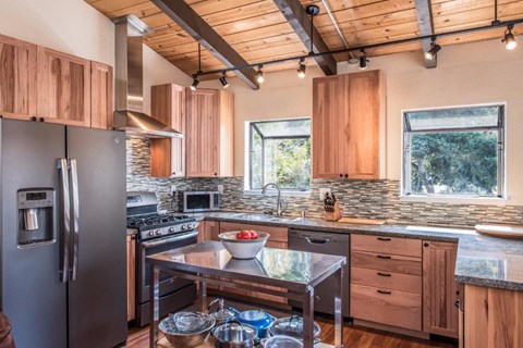 A kitchen with wooden cabinets and a black refrigerator.
